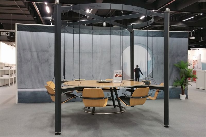 LOUNGETABLE von vorn: runder Holztisch, acht hängende Holzsitze, Metallgestell
