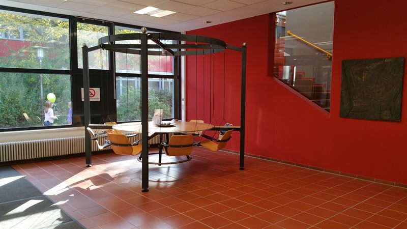 LOUNGETABLE vor großer Fensterfront im Foyer