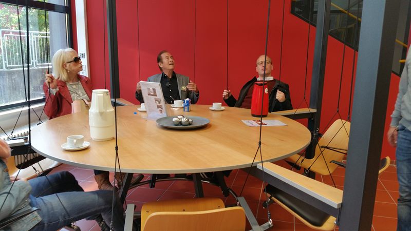 Gäste sitzen gut gelaunt an der Holztischplatte des LOUNGETABLE